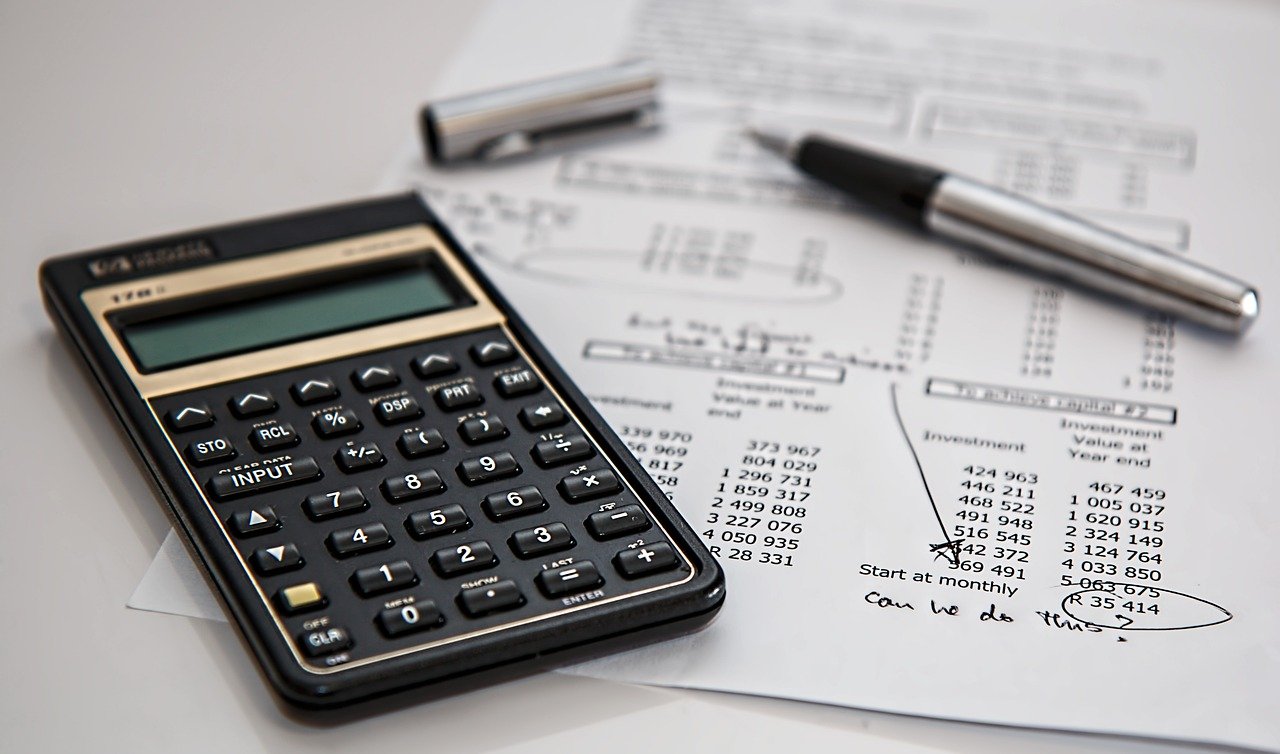 Nómina y calculadora sobre escritorio con gráficos laborales